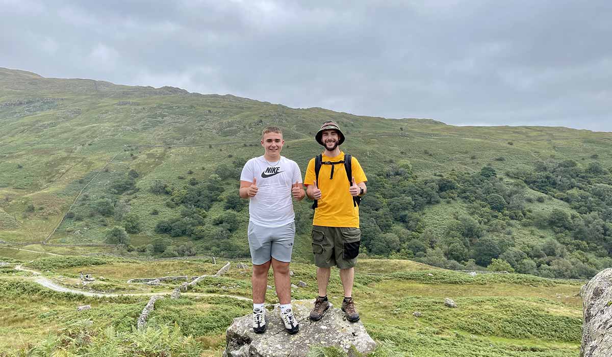 george-and-steve-hike Steve and his nephew George standing on a rock on a hillside, both giving a thumbs up.